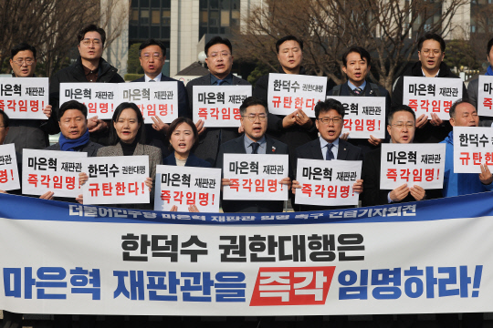박찬대(앞줄 왼쪽 네번째) 더불어민주당 원내대표 등 민주당 의원들이 1일 정부서울청사 앞에서 기자회견을 열고 한덕수 대통령 권한대행 국무총리의 마은혁 헌법재판관 후보자 임명을 촉구하고 있다. [연합뉴스]